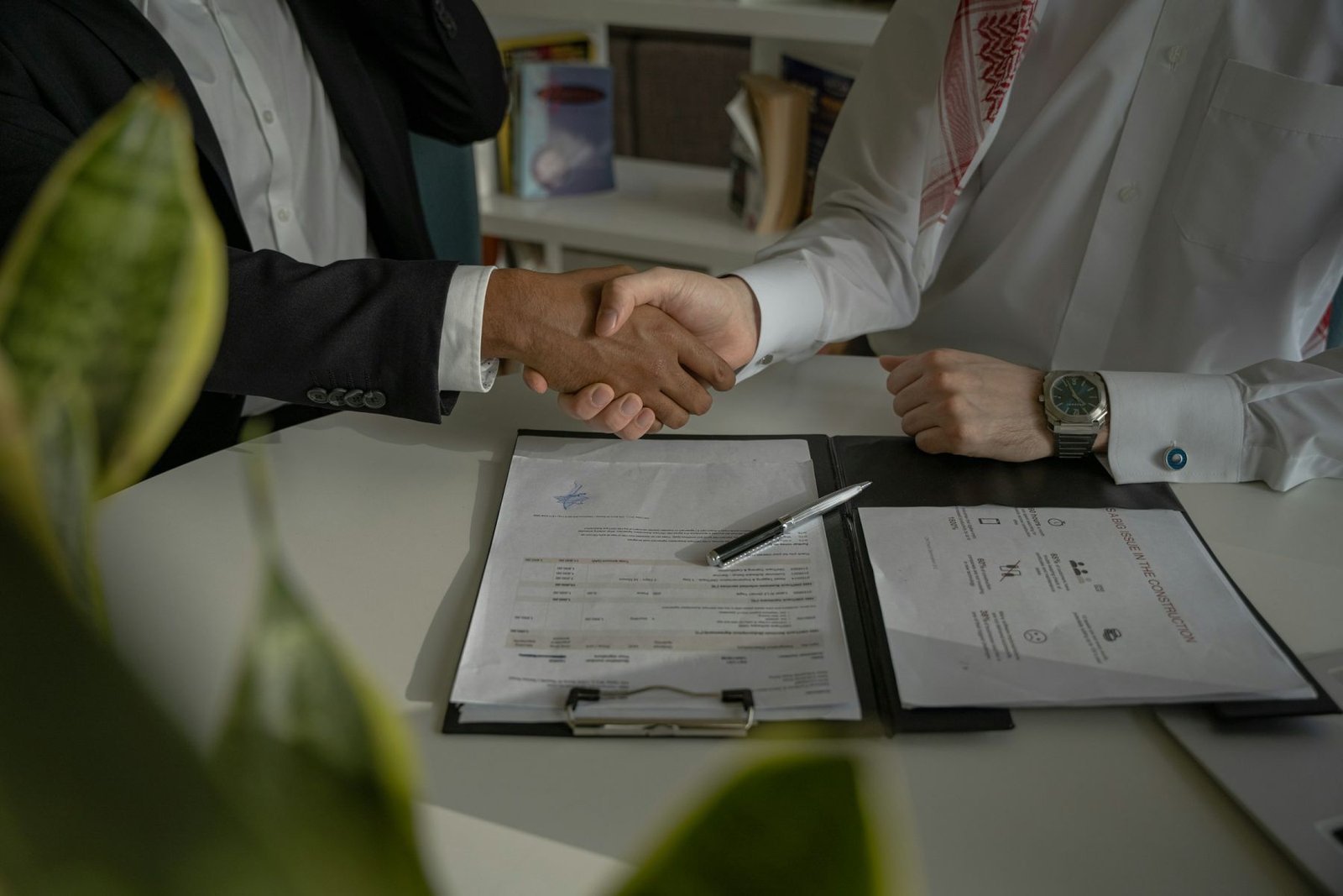 Two business partners shaking hands over an agreement